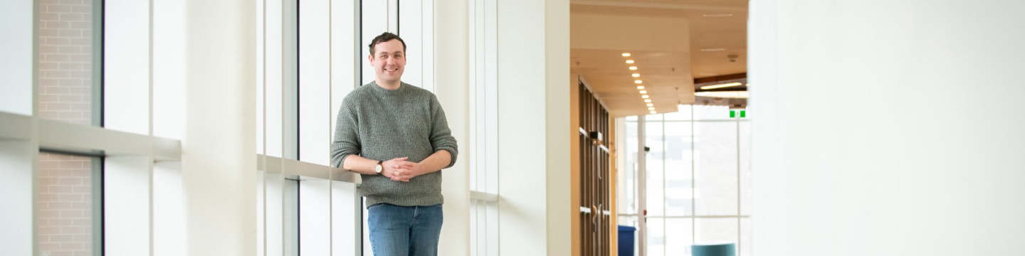 UPEI student Brennan McDuffee standing by windows