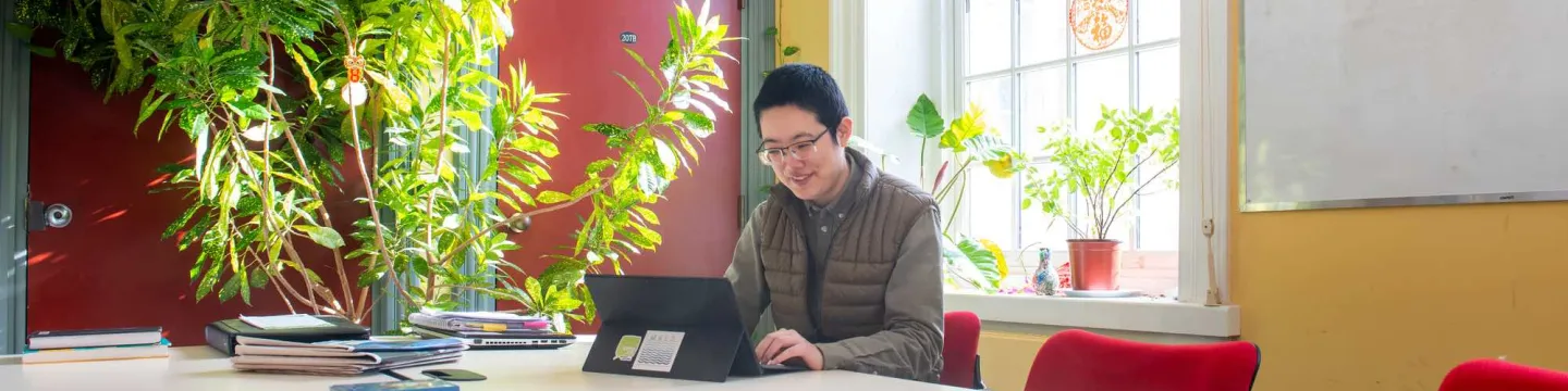 MAIS student Hexi Wang working in a student lounge