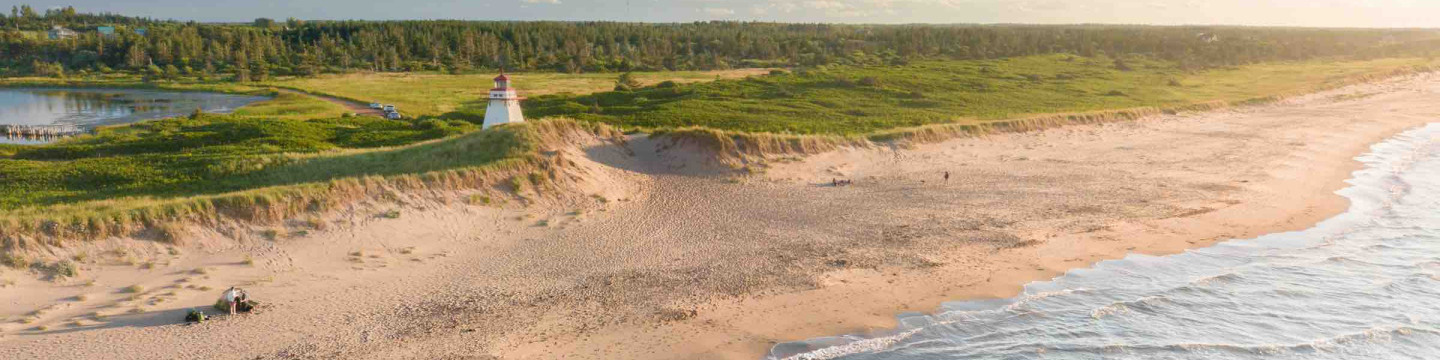 aerial photo of a PEI shoreline, sand, dunes, and a lighthouse