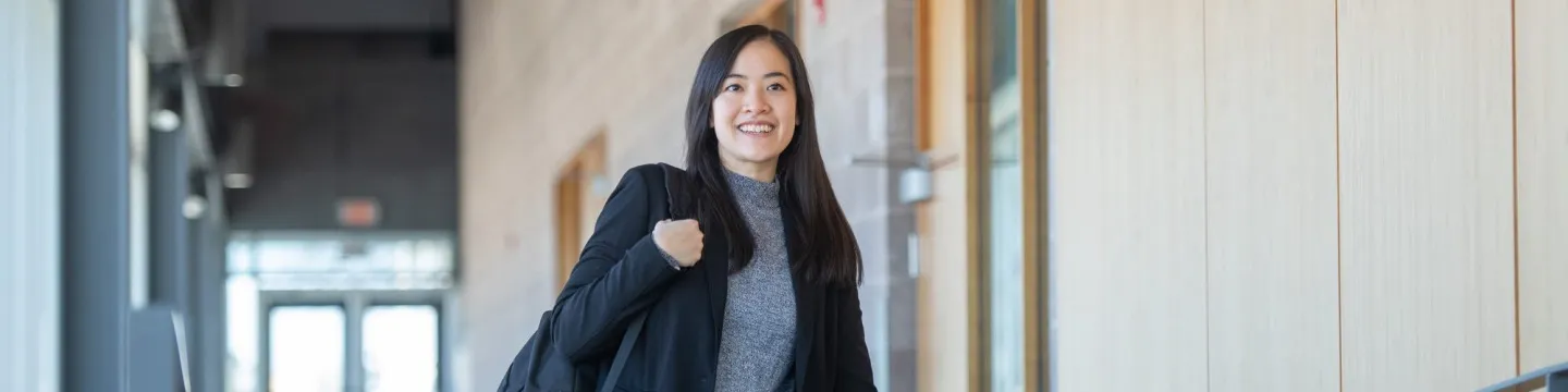 a smiling student walking in a hall