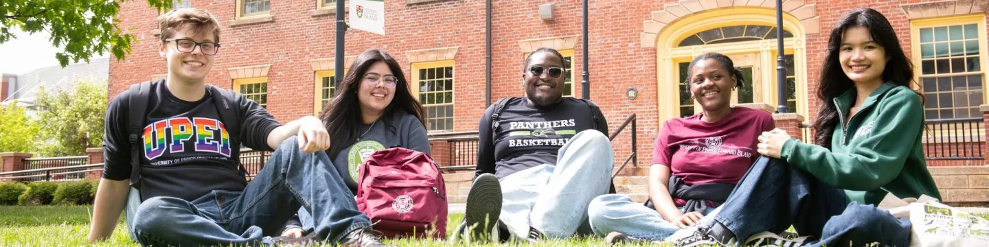 five students sitting in the quad outside UPEI's SDU Main Building