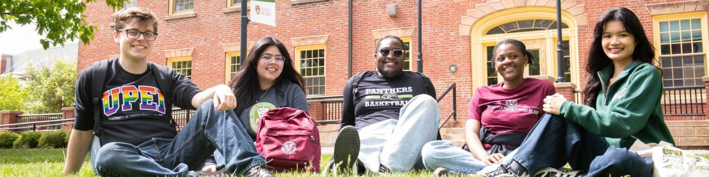 five students sitting in the quad outside UPEI's SDU Main Building