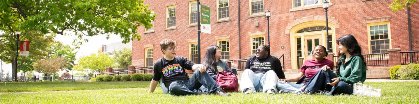 five students sitting in the quad outside UPEI's SDU Main Building