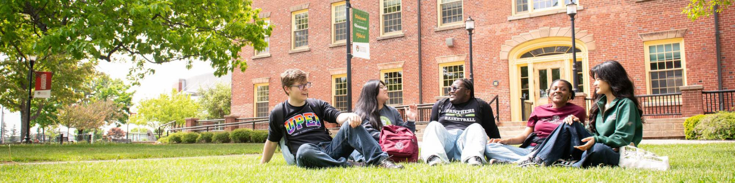 five students sitting in the quad outside UPEI's SDU Main Building