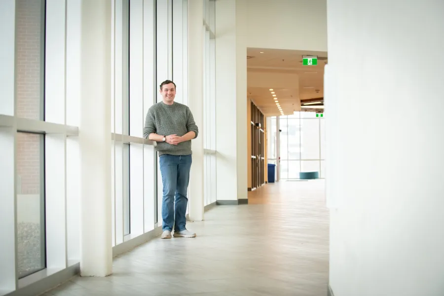  UPEI student Brennan McDuffee standing by windows