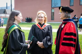 Dr. Nino Antadze speaks with a colleague and student outside UPEI convocation