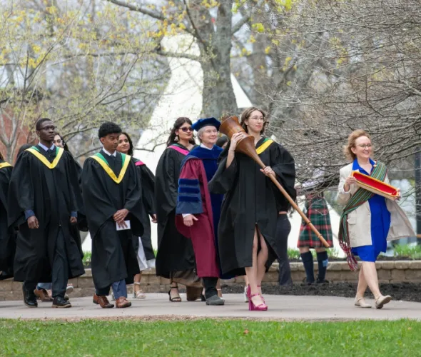 Marshal, Sue Dawson; Macebearer, Shanelle Berthier, Faculty of Science; and Eagle Feather Bearer, Erin Reid, assistant professor, Faculty of Indigenous Knowledge, Education, Research, and Applied Studies, lead graduates in the Faculty of Science into the Chi-Wan Young Sports Centre for their Convocation ceremony on May 16. 
