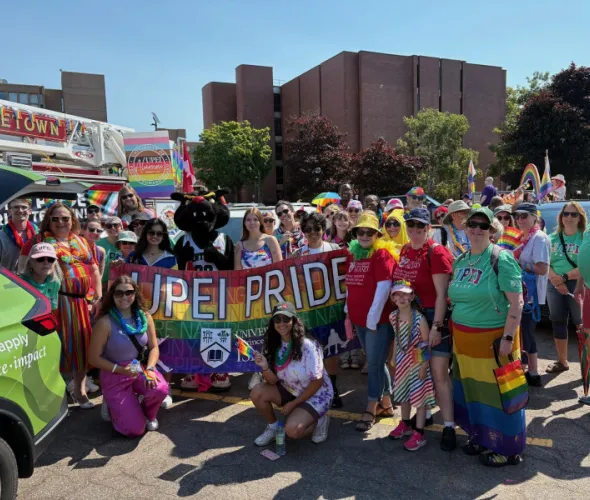 Photo of large group of people wearing rainbow colours 