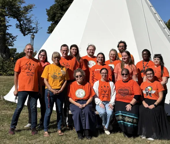 photo of people in front of a tipi