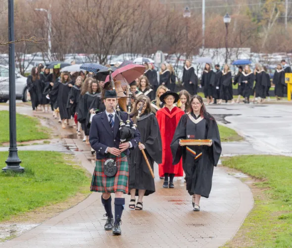 Graduates in the UPEI faculties of Nursing and Veterinary Medicine are led into the Chi-Wan Young Sports Centre for their Convocation ceremony on May 12 by Marshal Dr. Lisa Chilton; Macebearer Dr. Laura Groves, Faculty of Veterinary Medicine; and Eagle Feather Bearer Andrea Gallant, Faculty of Nursing. 