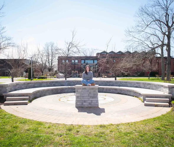 UPEI student Annika Masters in the stone theatre outside the Chaplaincy Centre